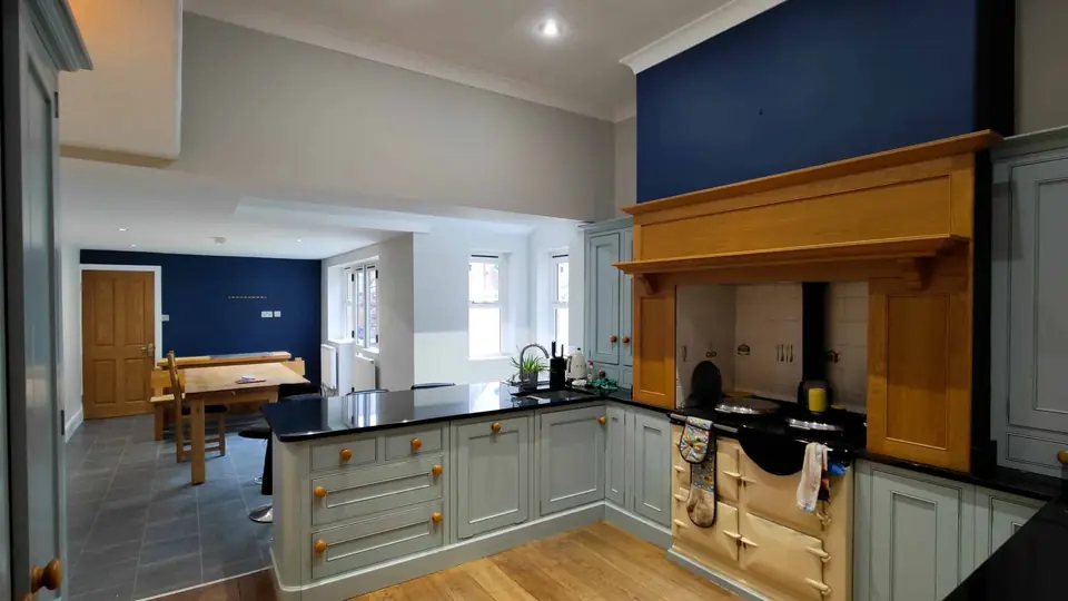 Kitchen redecorated in navy and sage green with feature chimney breast