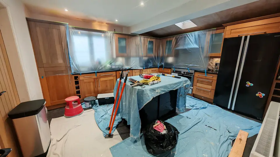 We protect your home: oak kitchen units masked in polythene, floor under dust sheets