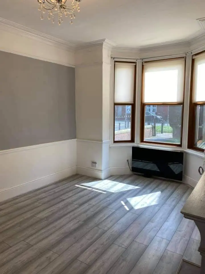Grey laminate flooring in a bay-window room with panelling