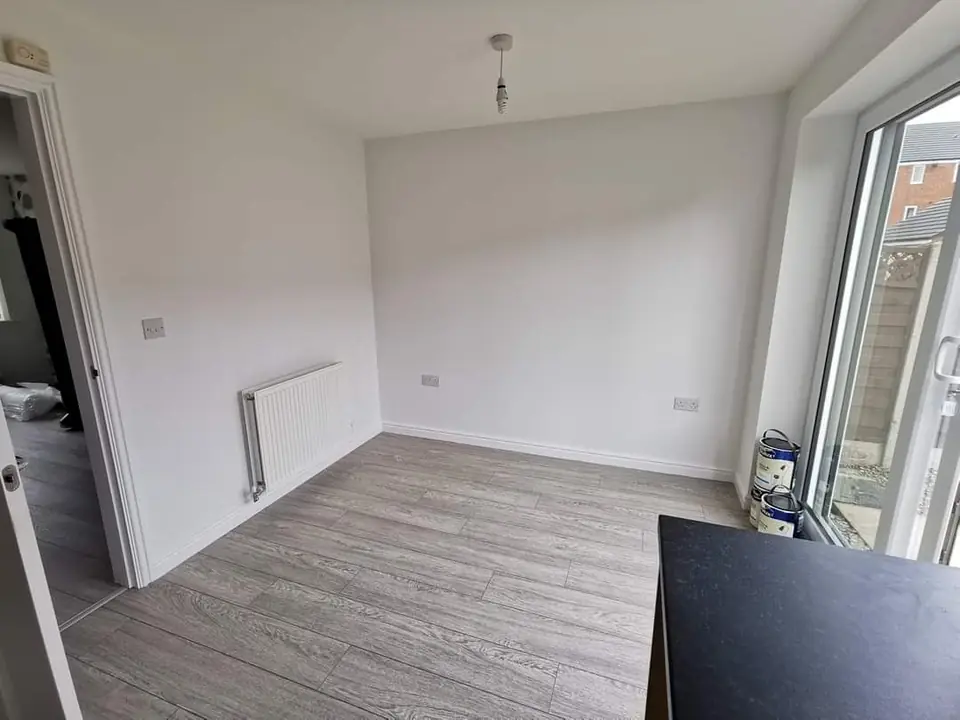 Grey wood-effect laminate floor in a bright lounge with patio doors