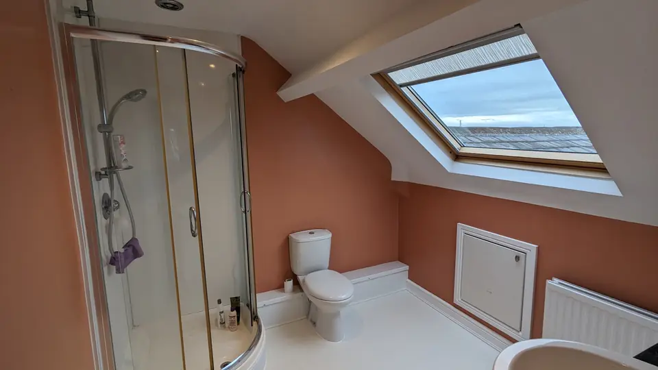 After: terracotta loft bathroom with corner shower