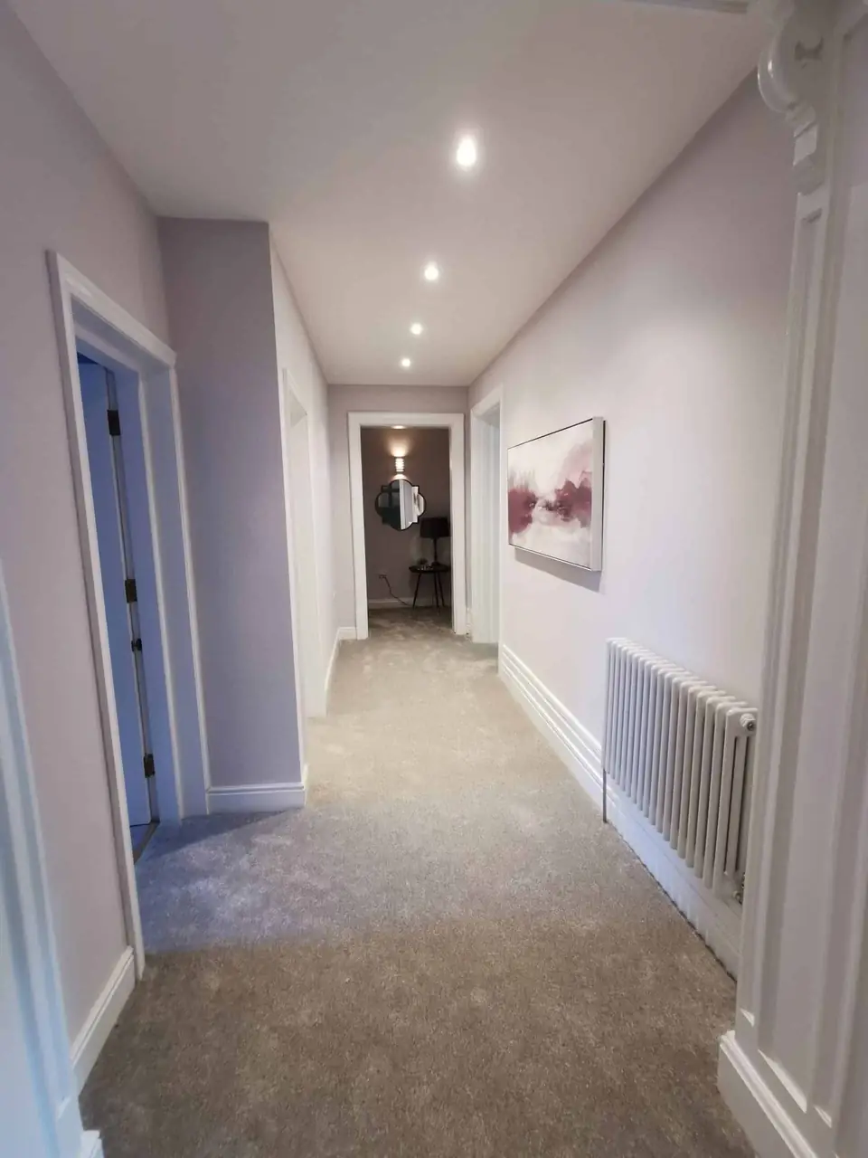Long hallway painted in light grey with white woodwork