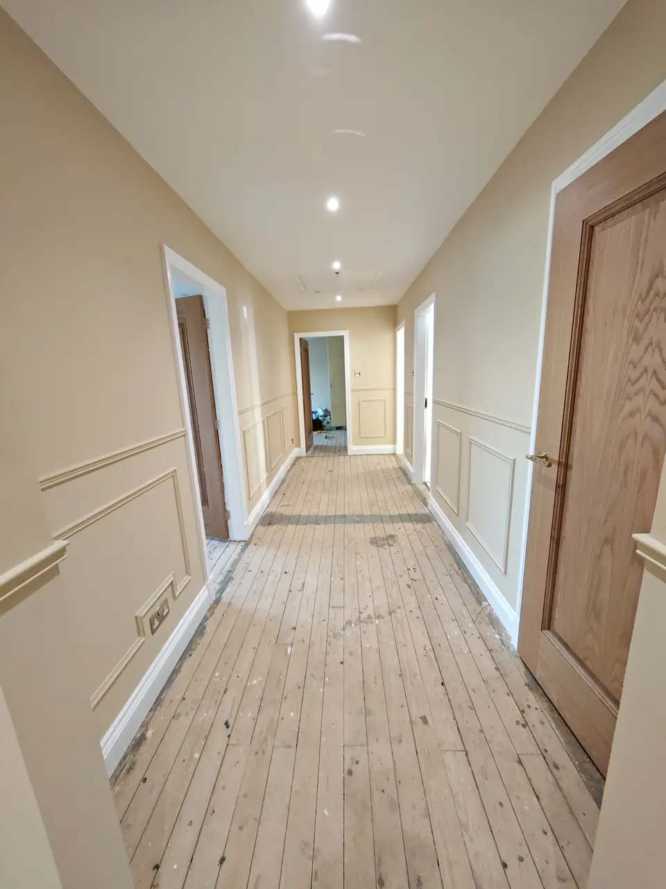 Long hallway with painted box panelling and dado rail
