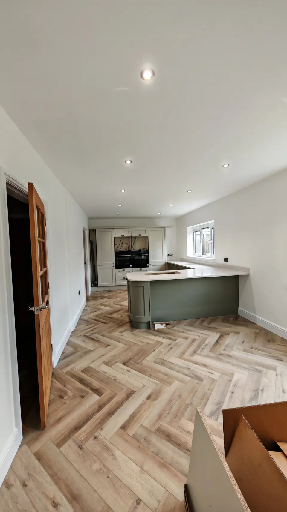 Herringbone LVT flooring through a kitchen-diner