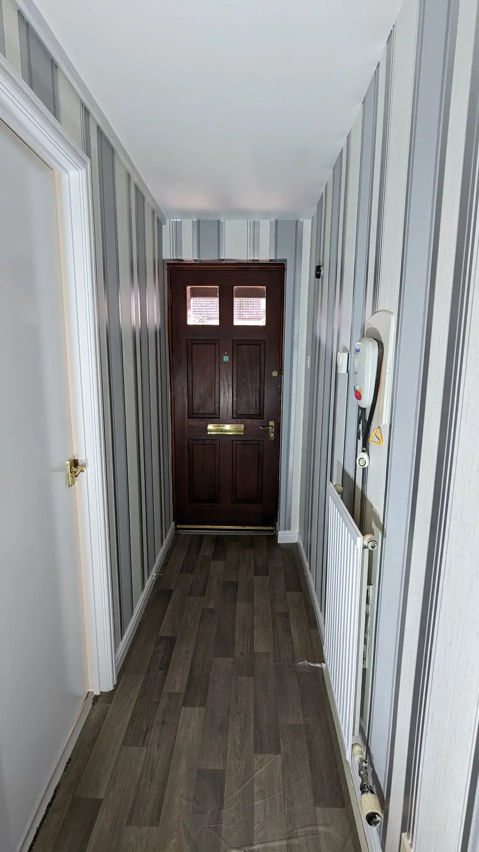 Dark oak-effect LVT plank flooring in a long hallway
