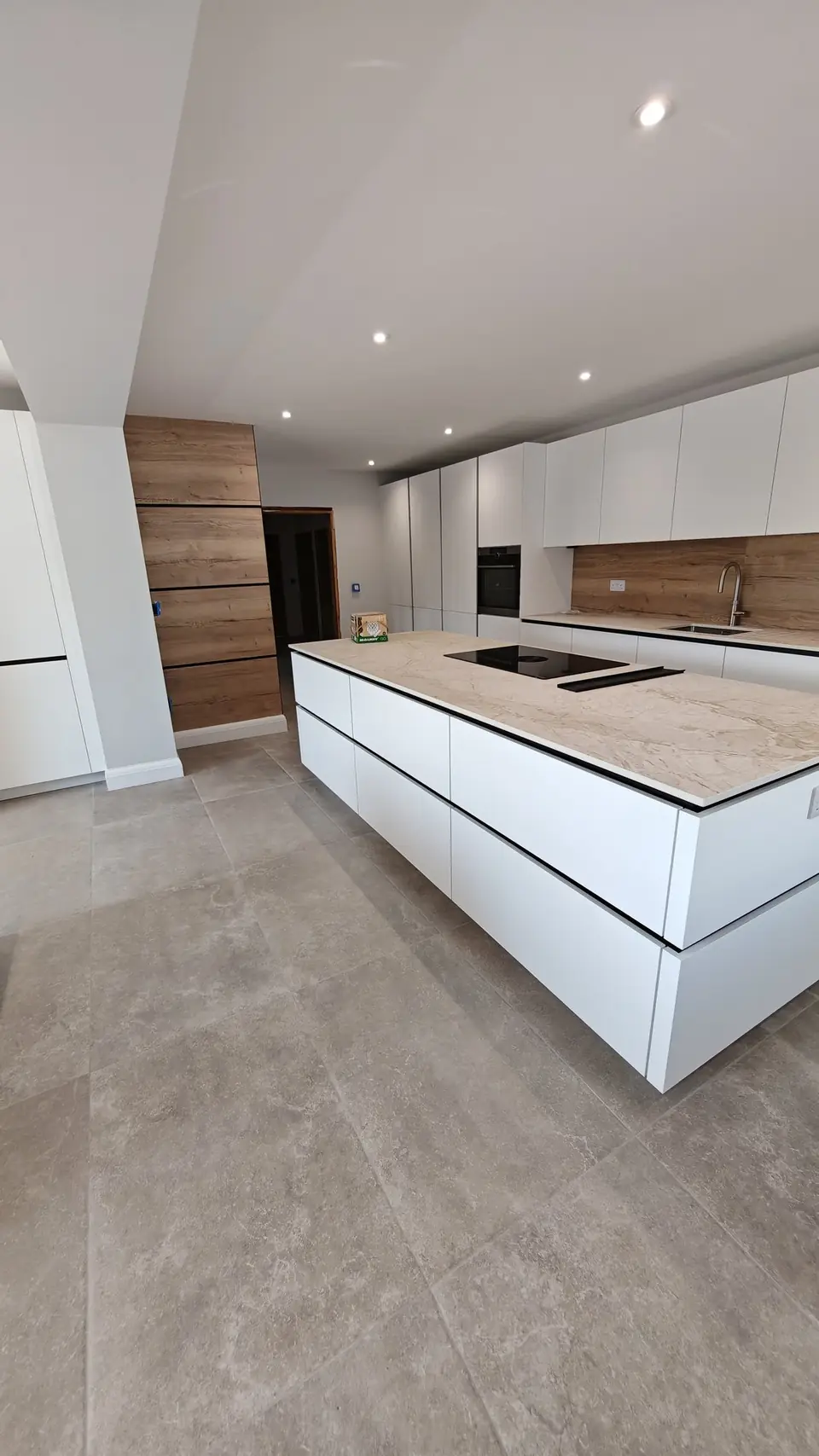 New white handleless island kitchen with freshly decorated walls and ceiling