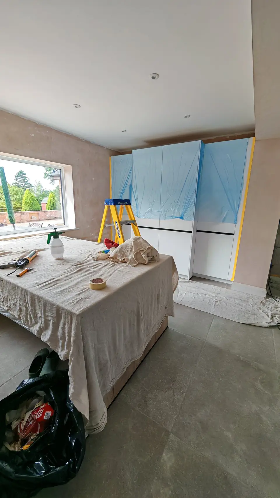 Before: new tall units fully masked and protected, walls in bare plaster