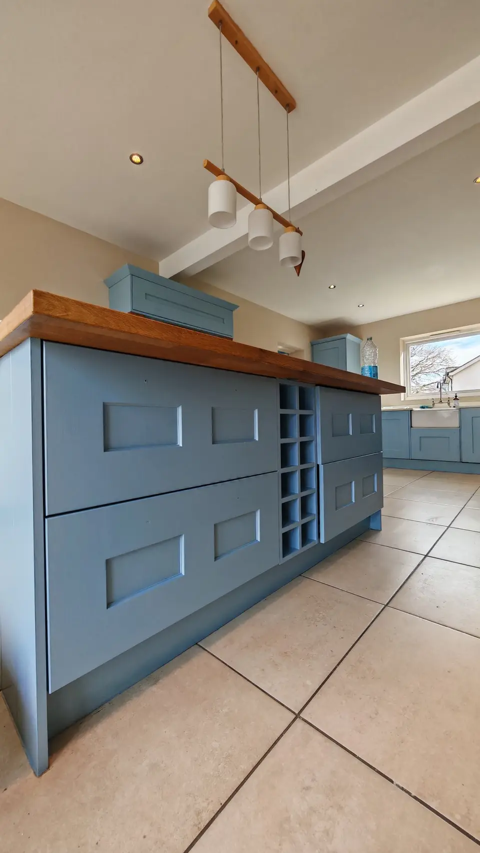 Island drawers and wine rack in soft blue under the oak top