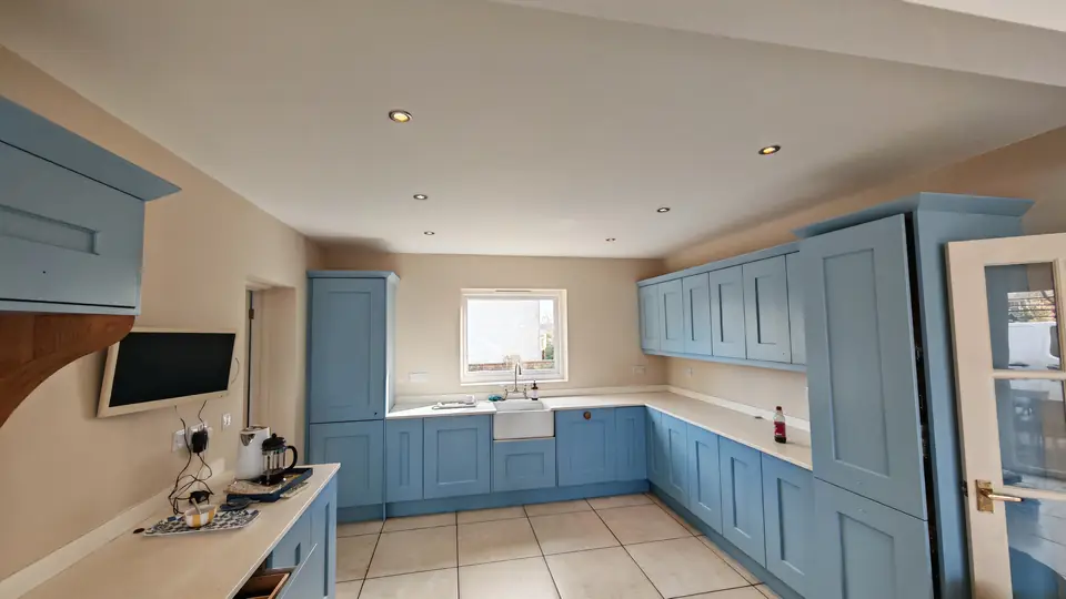 Soft blue kitchen: Belfast sink run under the window, tall larder unit and wall units resprayed