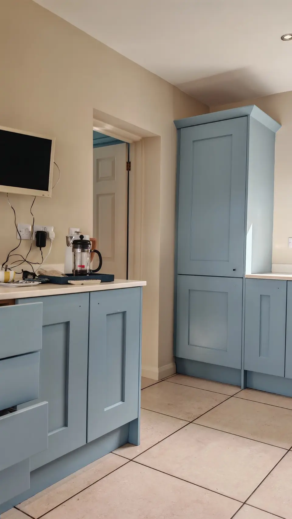 Tall larder unit resprayed soft blue by the doorway