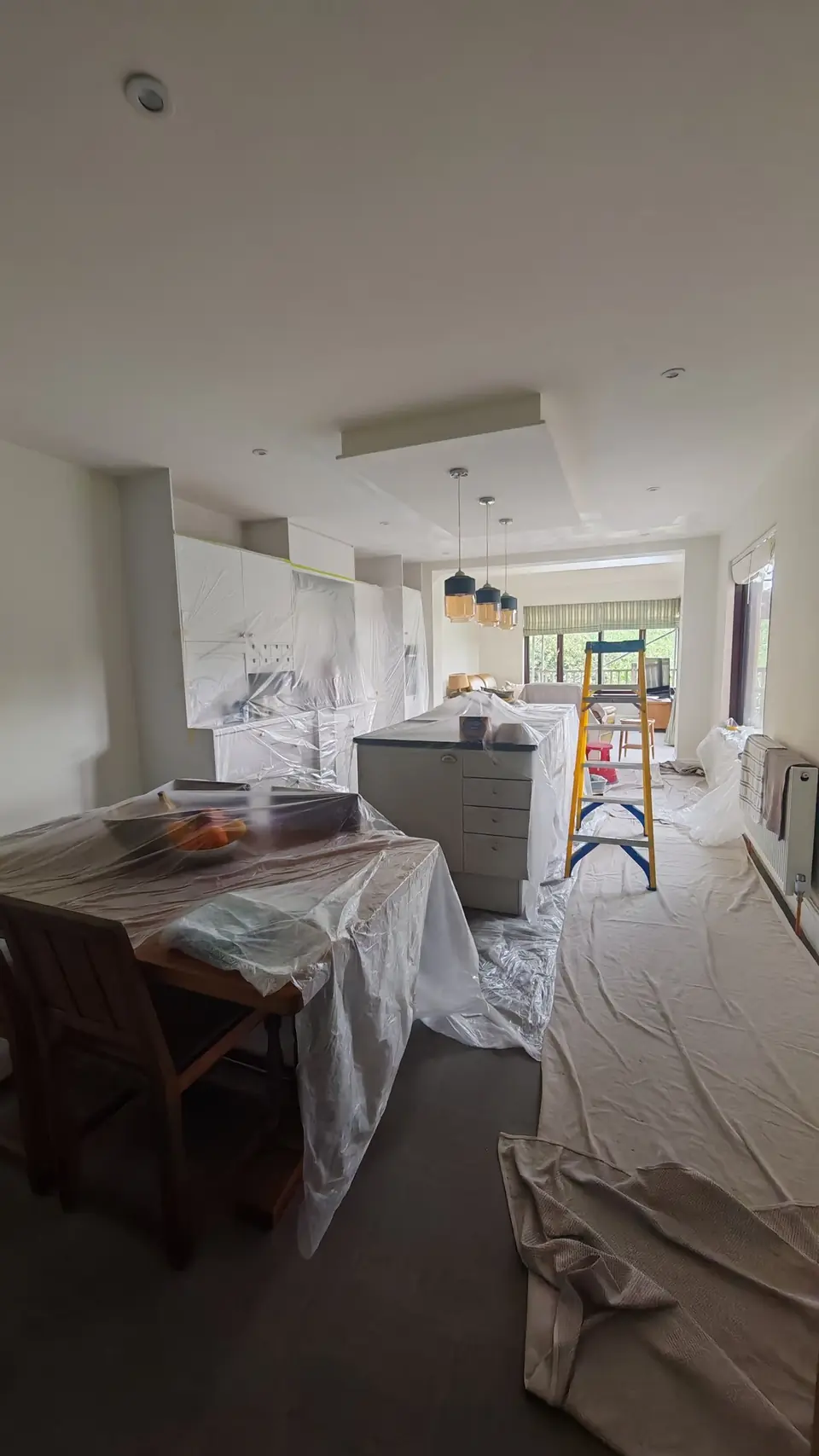 During: the whole kitchen masked and dust-sheeted before painting