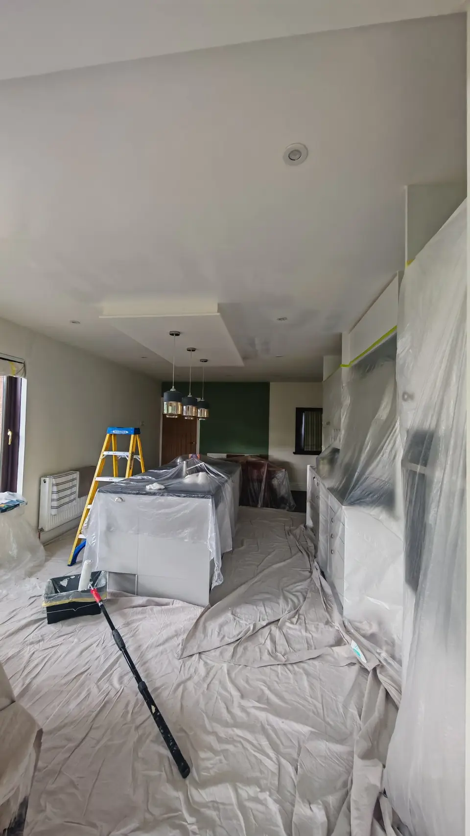 During: island and units wrapped, ladder up for the ceilings
