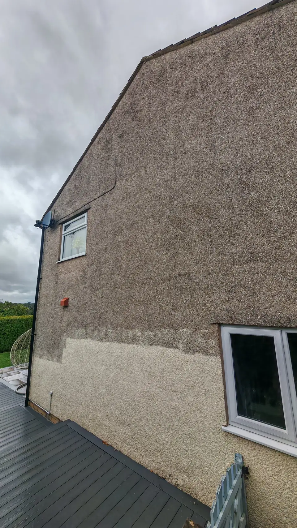 The difference in one photo: gable wall half painted, cream masonry paint over dirty pebbledash
