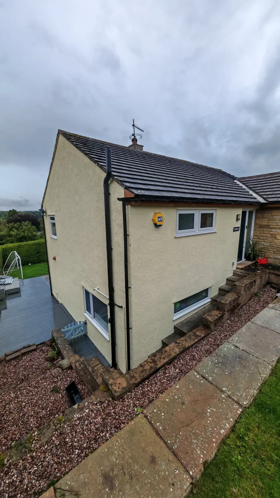 After: side gable of the pebbledash house painted cream