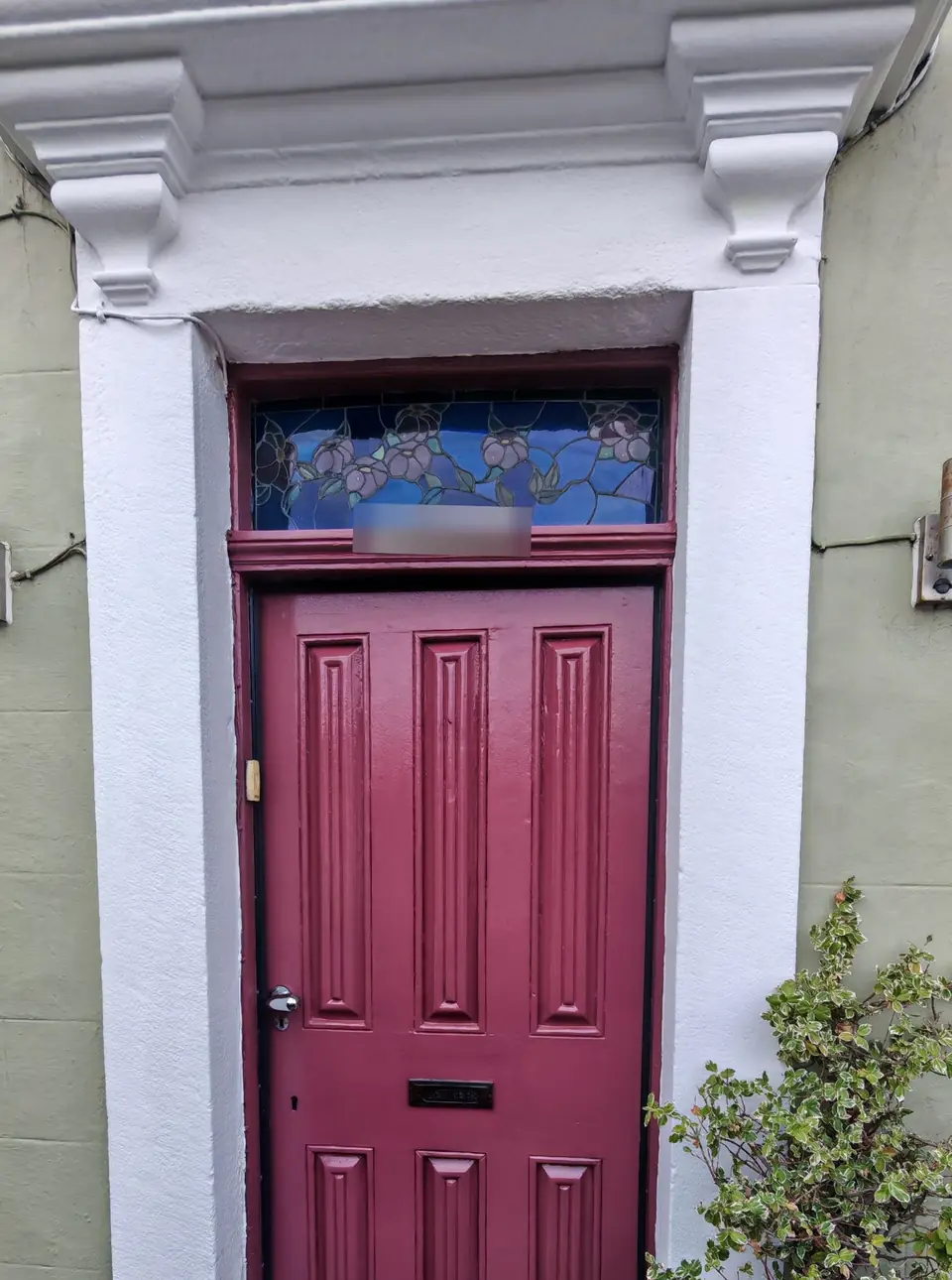 After: the same door glossed in burgundy, surround and canopy repainted brilliant white