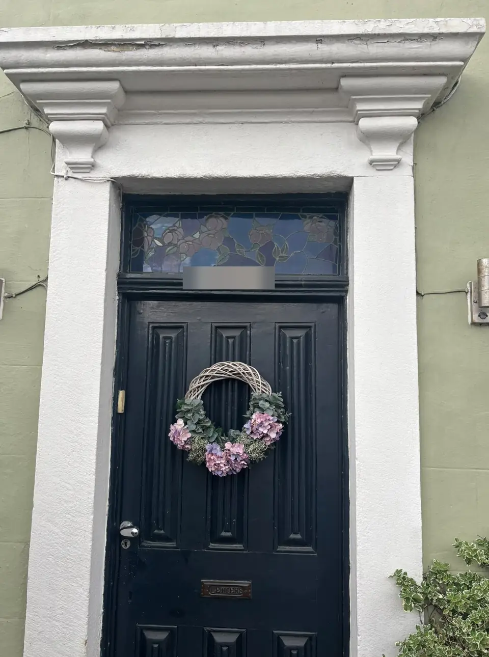 Before: black front door with a flaking stone surround and canopy
