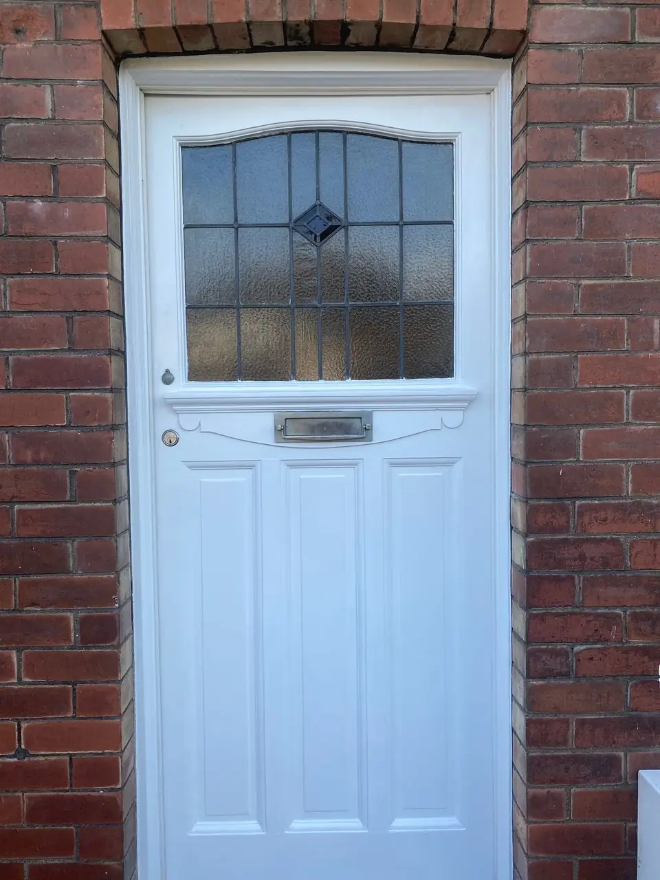 Period timber front door with leaded glass, repainted crisp white