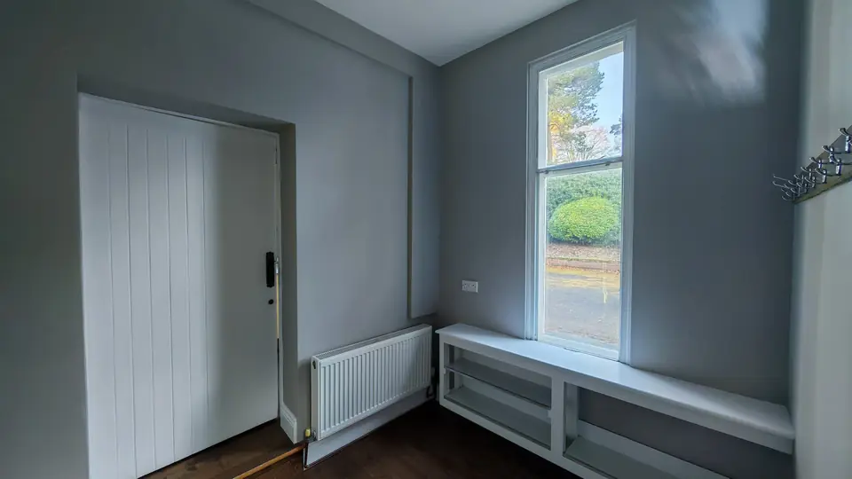 Entrance hall: white door and bench, soft grey walls