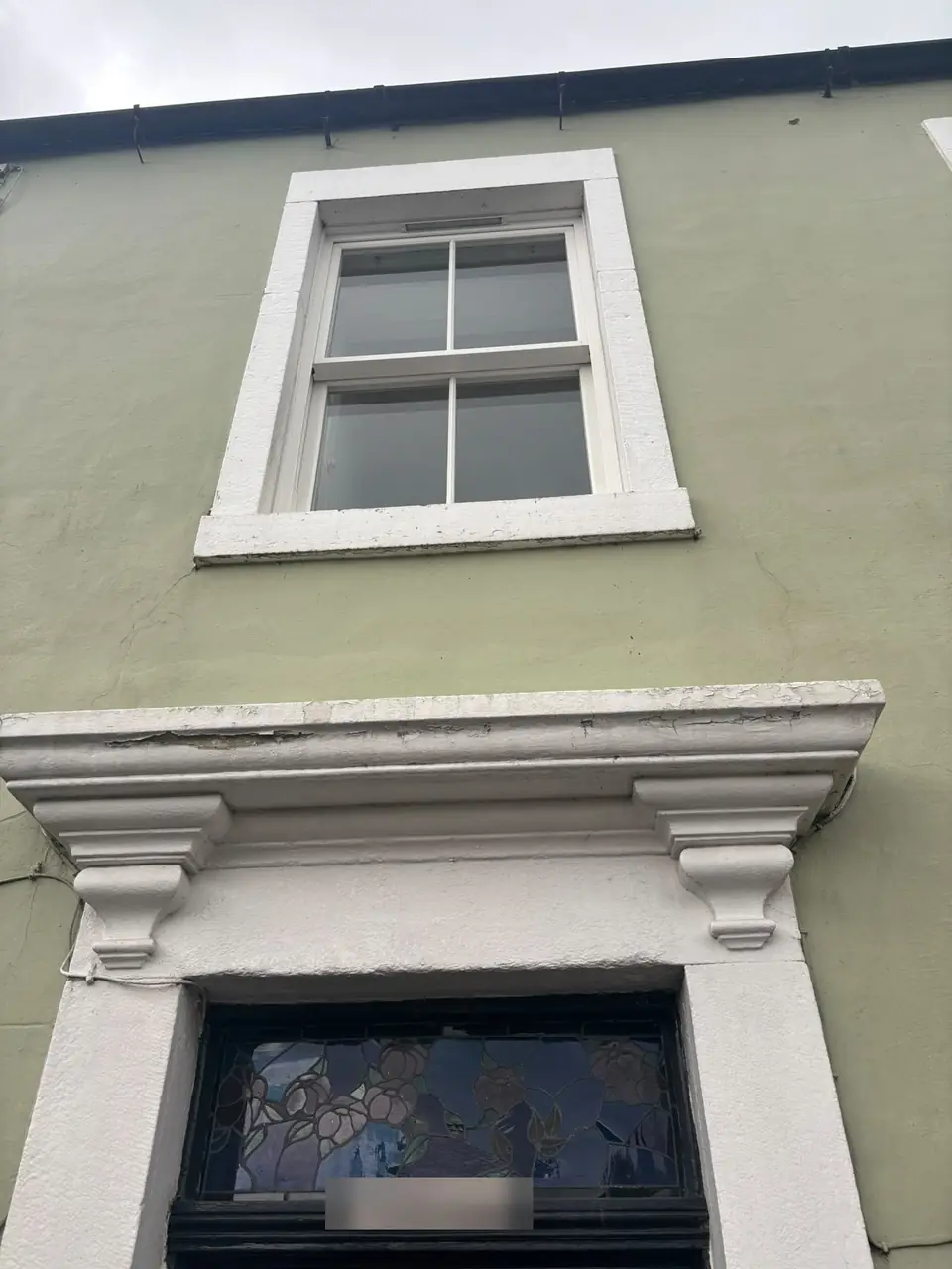 Before: weathered door canopy and upper window surround