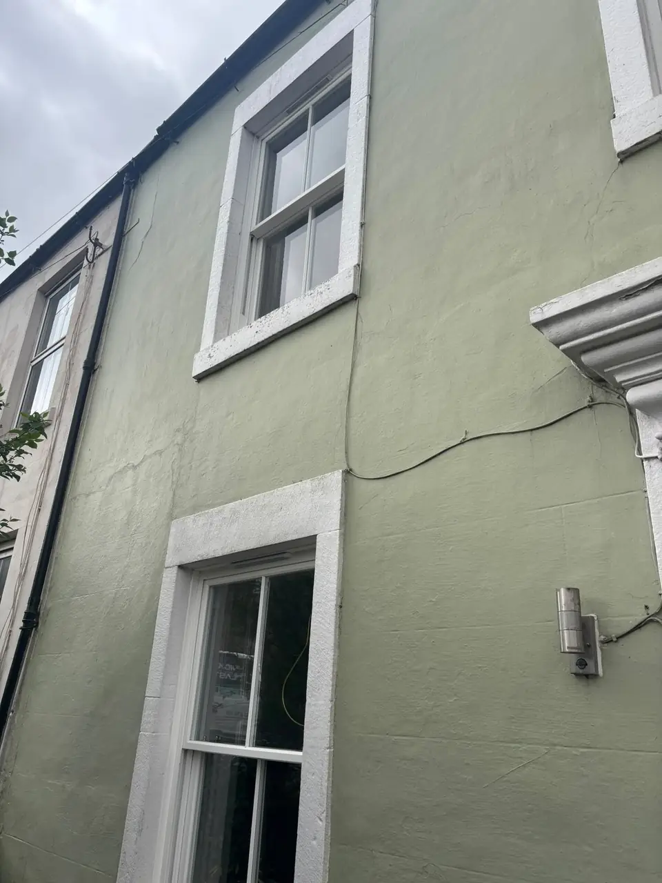 Before: tired window surrounds on the sage green render