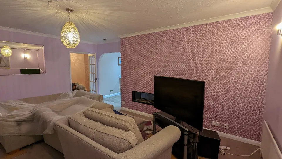 Living room decorated in soft blush pink with chandelier