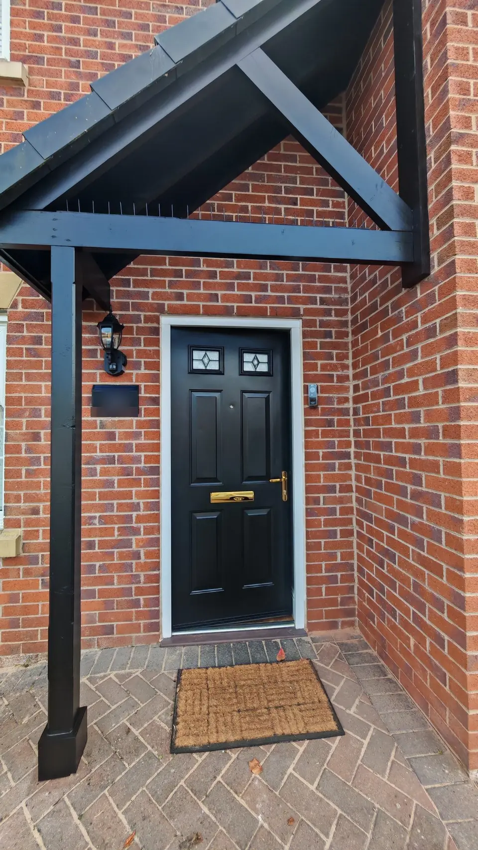 New motion-sensor wall light and slate house sign fitted by the front door, which was glossed black