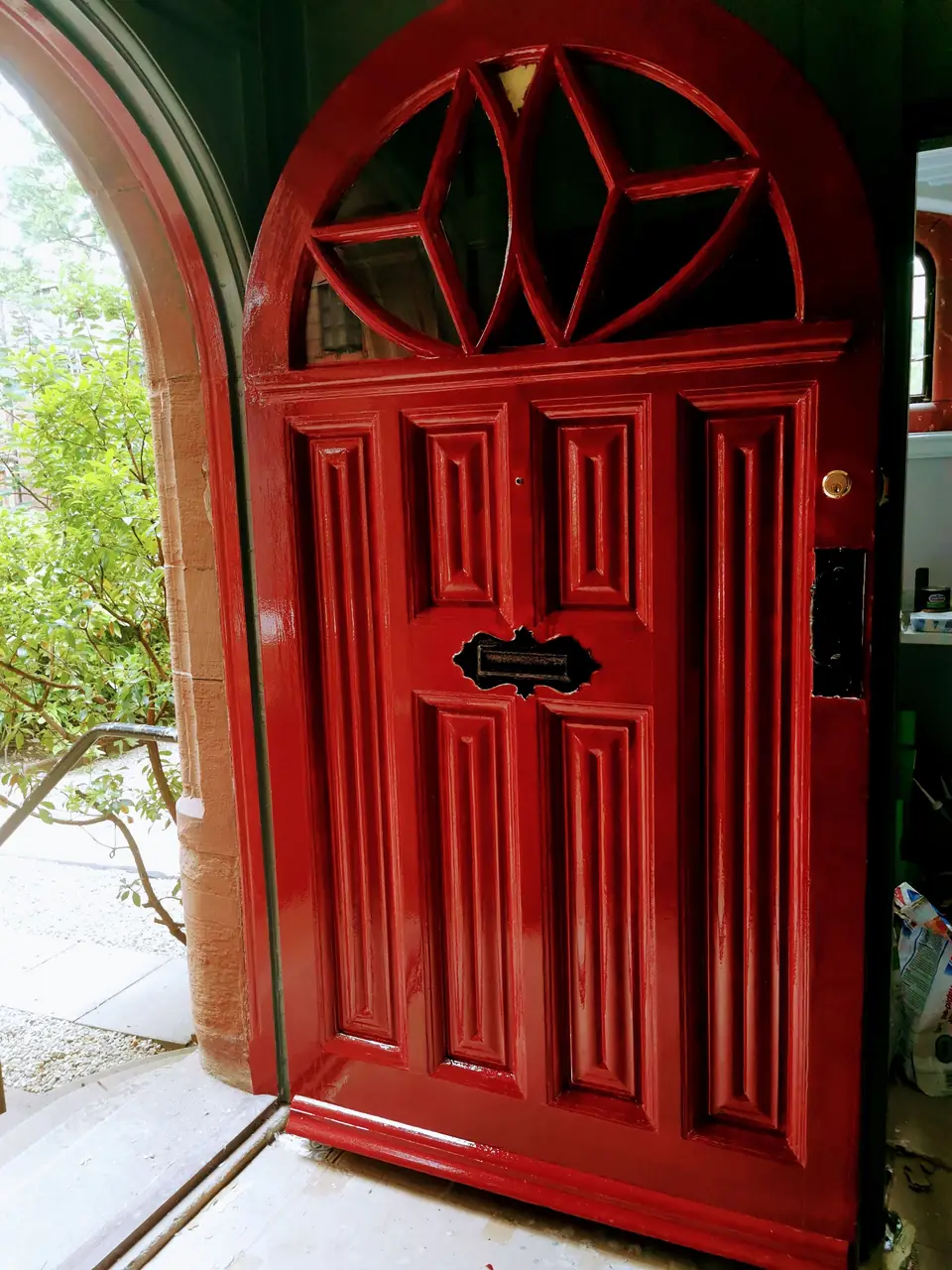 Arched panelled front door finished in high-gloss red