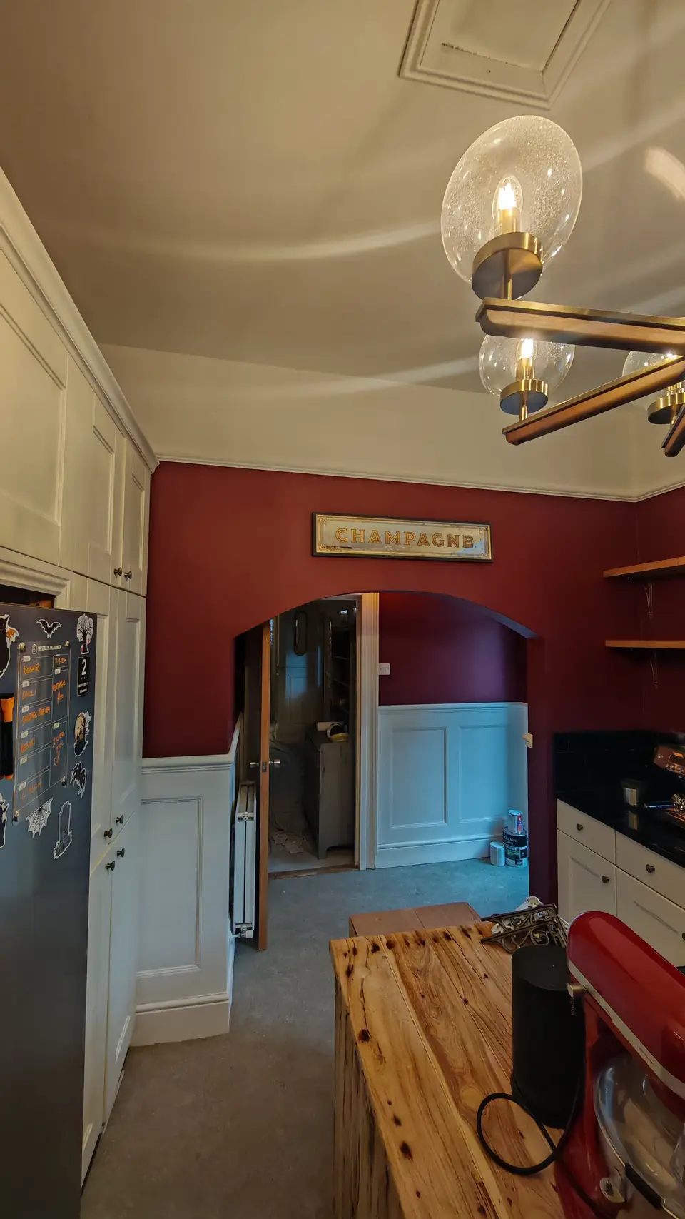 After: burgundy archway into the redecorated kitchen
