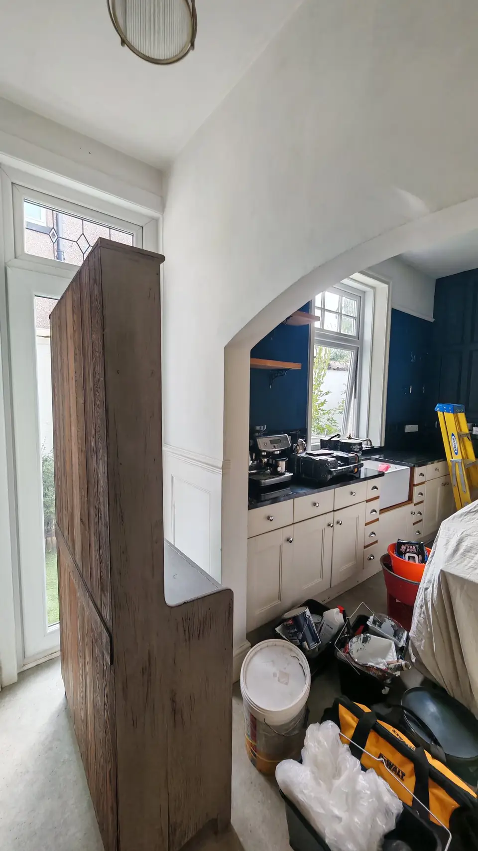 Before: navy walls by the sink, viewed through the arch