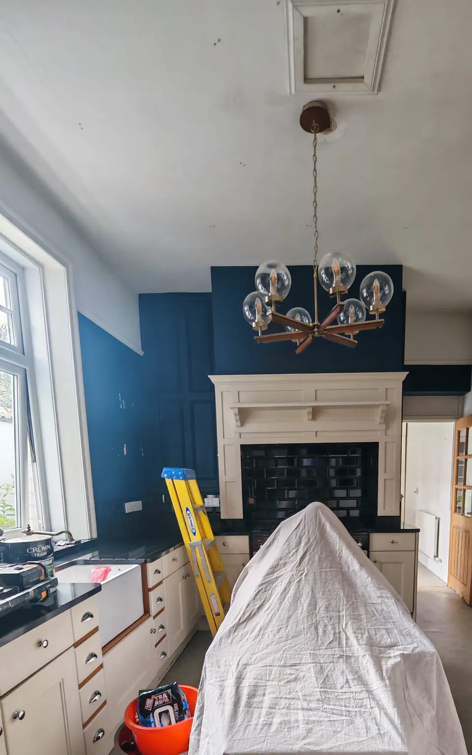 Before: navy blue kitchen walls, worn cream units and the island under a dust sheet