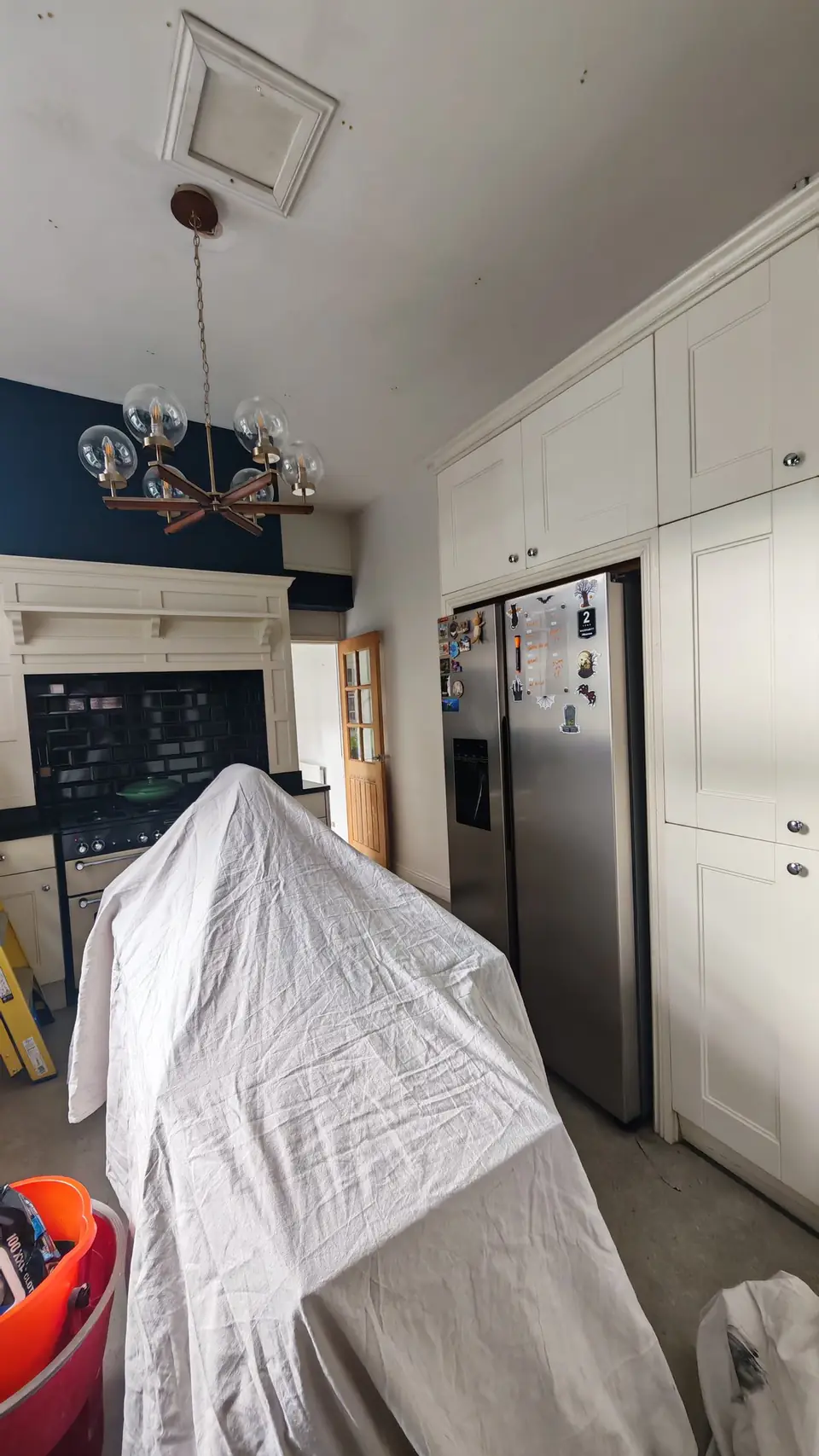 Before: navy walls, tall cream units and the island covered up