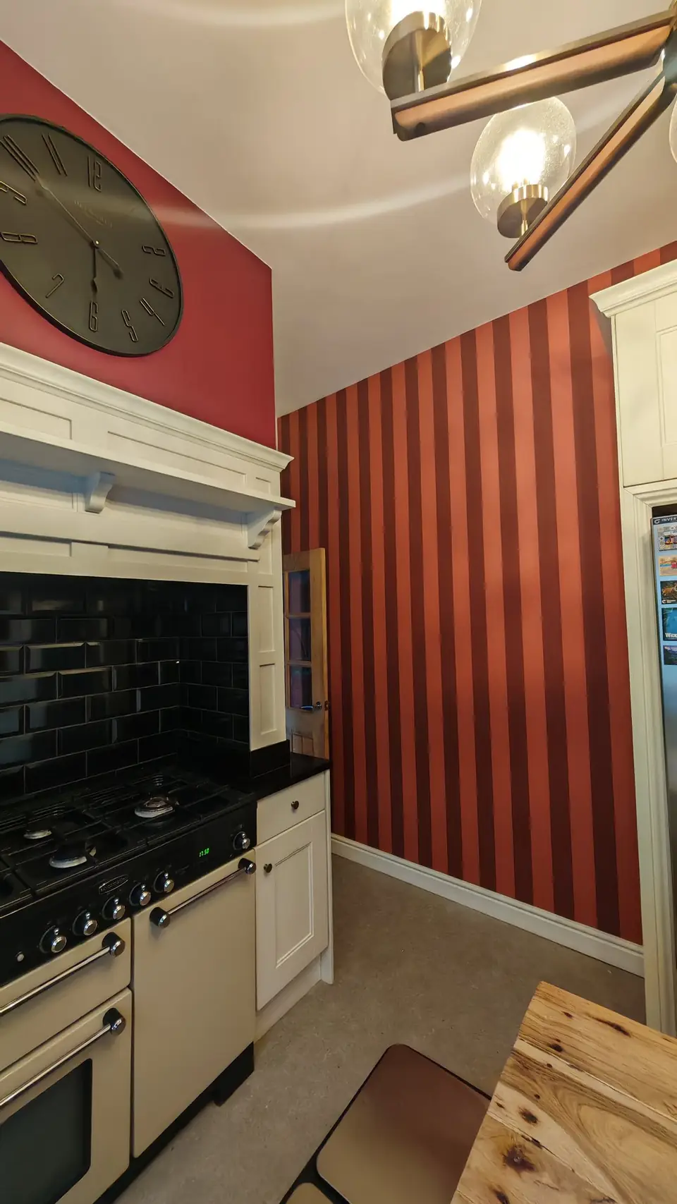 After: striped wallpaper beside the range cooker and freshly resprayed cream cabinets