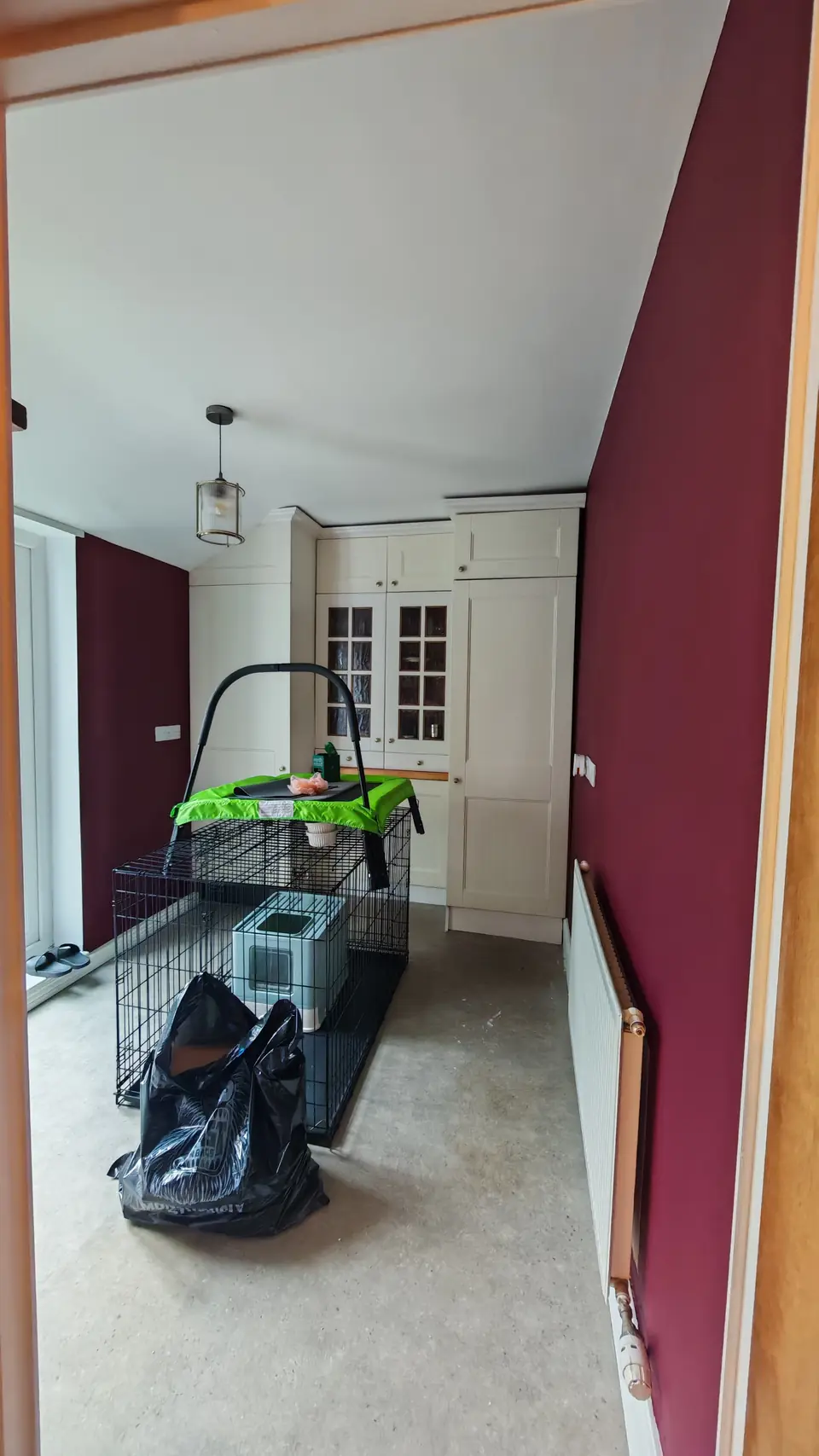 After: utility area with cream cabinets and burgundy walls