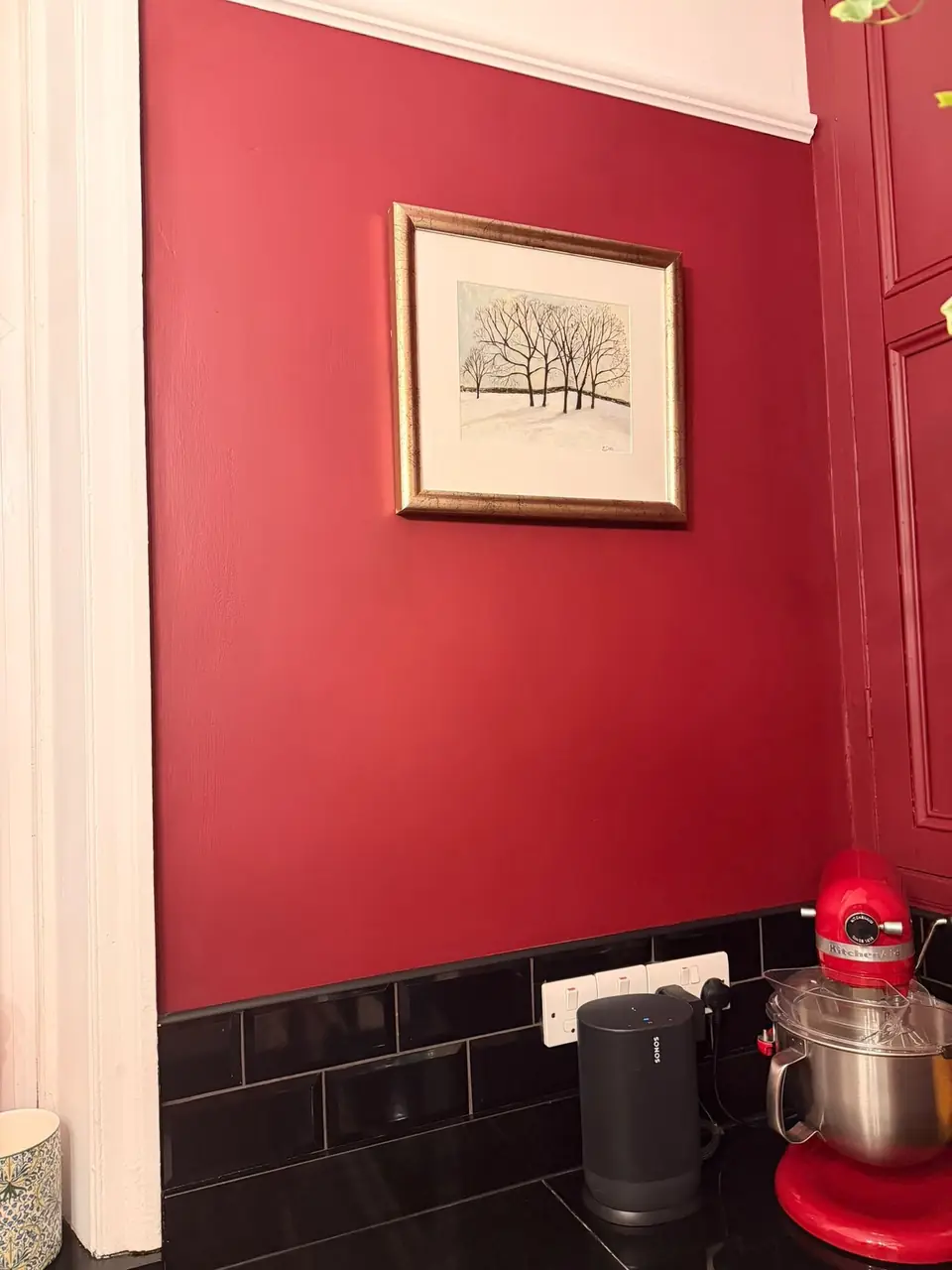 Deep red wall with framed picture above metro tiles