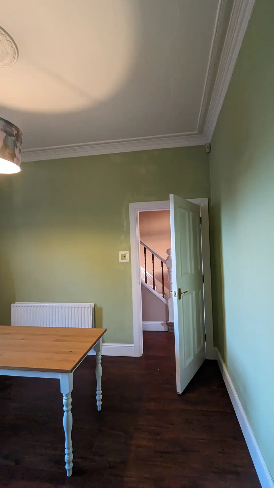 Sage green dining room towards the hallway