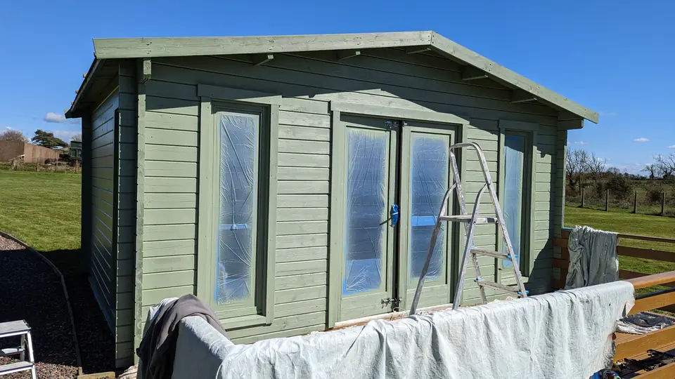 Timber garden room painted sage green with white trims