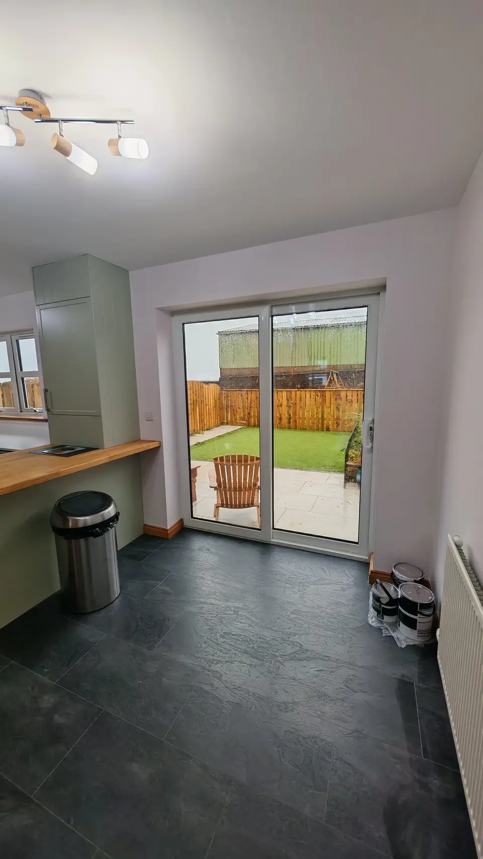 Sage green kitchen with oak breakfast bar beside the patio doors