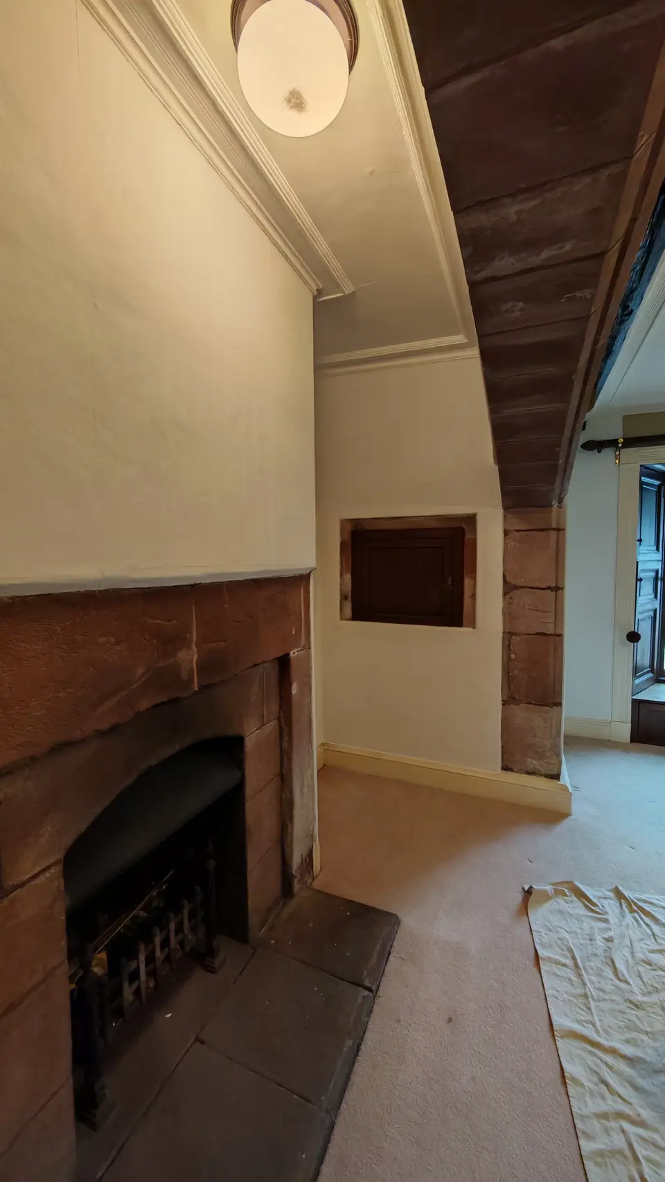Fireplace alcove finished in clean white beside the sandstone surround