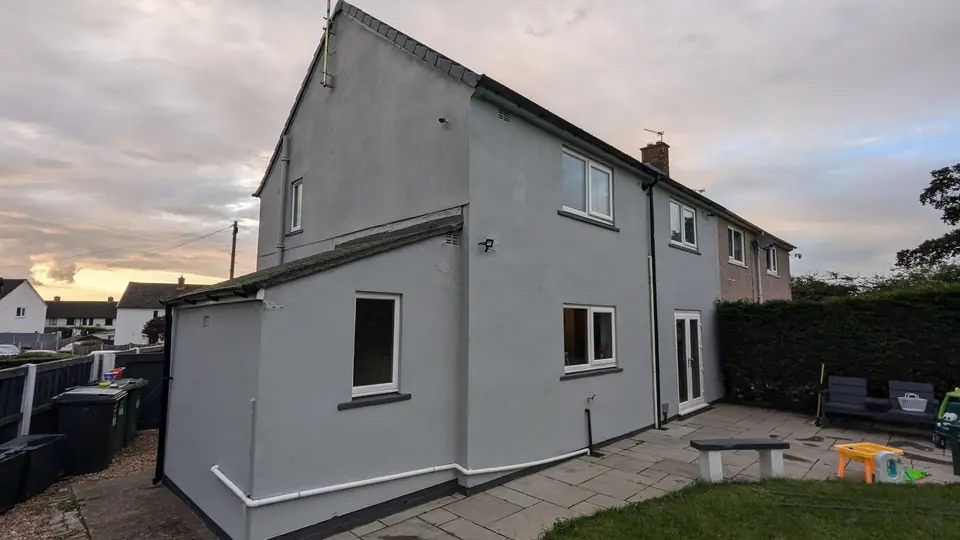 After: light grey render with dark plinth line