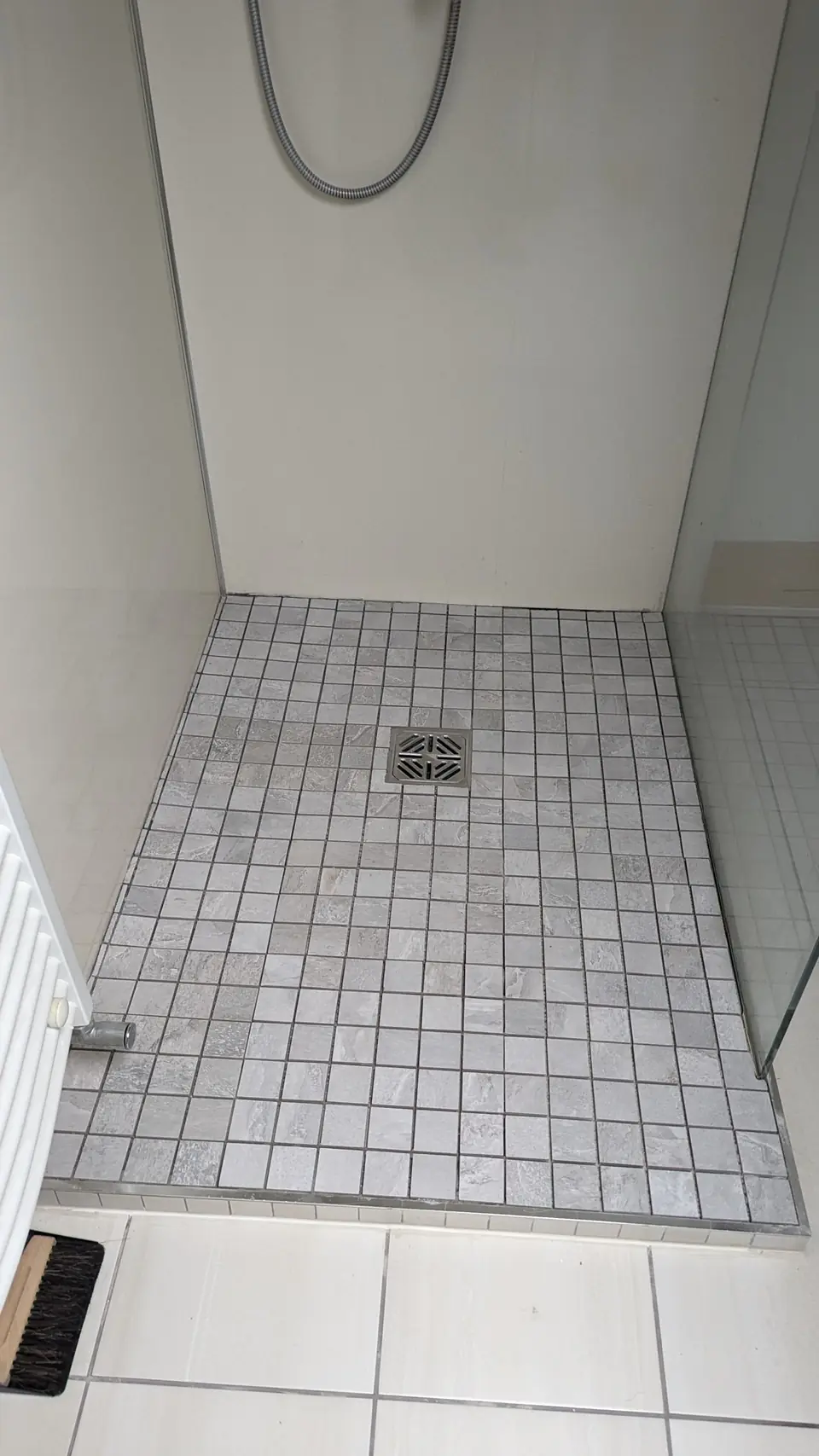 Mosaic tiled shower floor with central drain