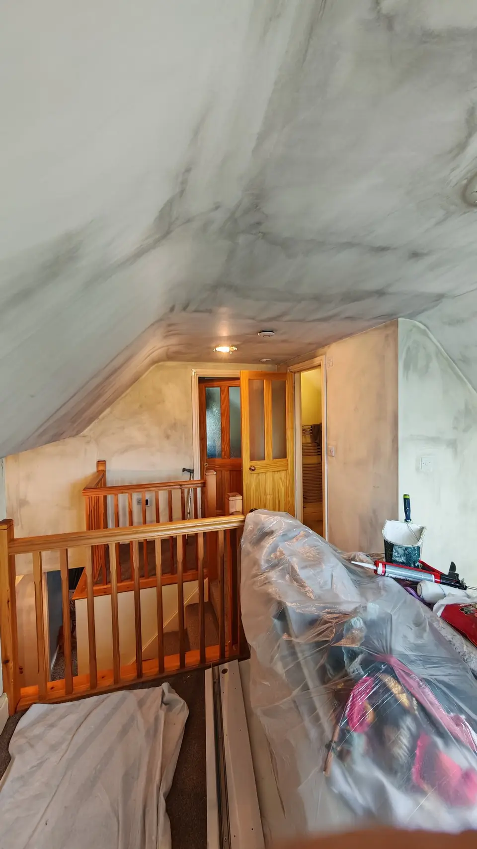 Before: smoke-stained landing ceiling above the banister