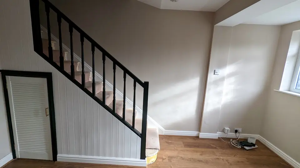Hallway with white panelling and black painted staircase spindles