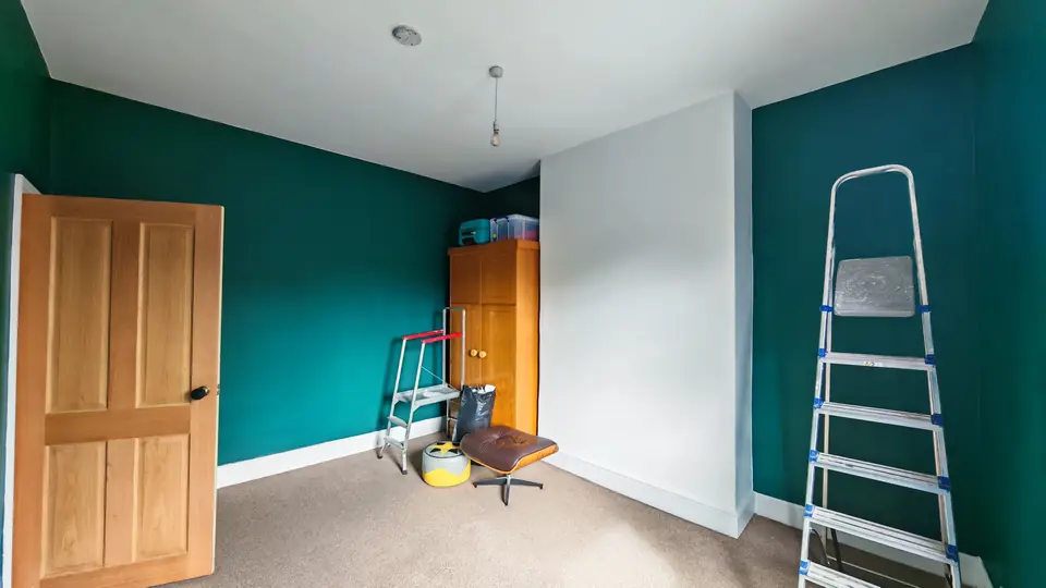 Bedroom with deep teal walls, white ceiling and a natural pine door