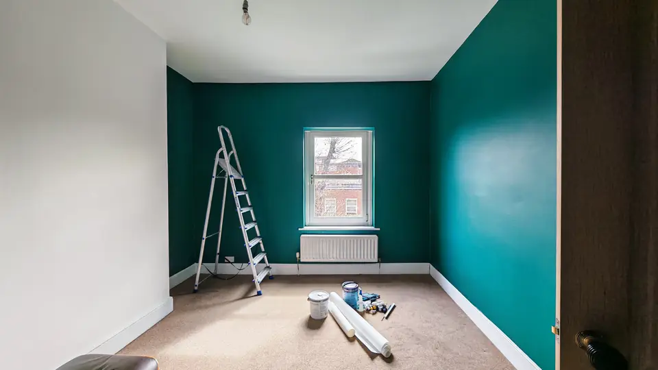 Deep teal bedroom painted wall to wall around a white window
