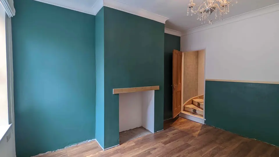 Deep teal room with a chimney breast and two-tone walls below the dado