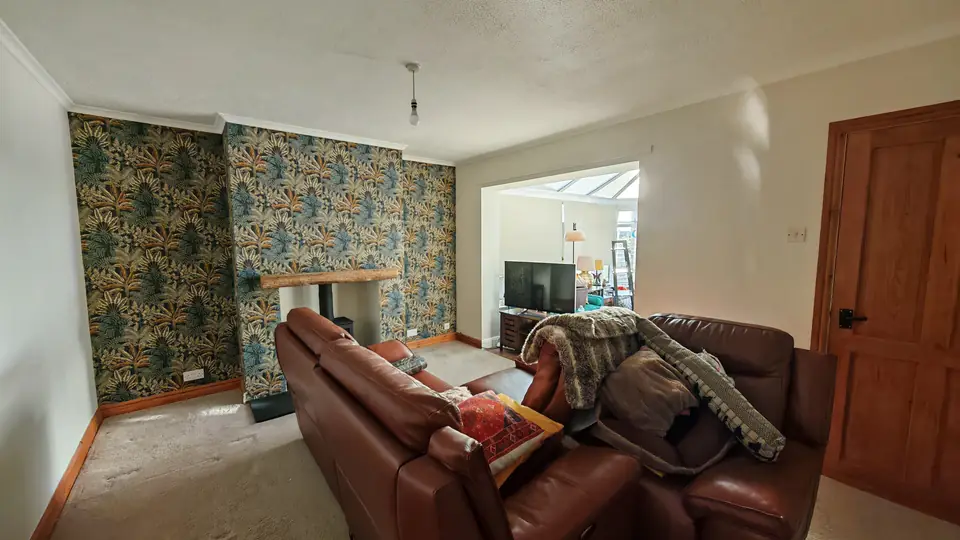 Living room looking through to the conservatory, tropical feature wall