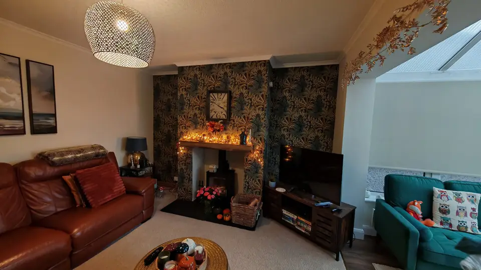 Styled lounge with a bold tropical wallpaper feature chimney breast