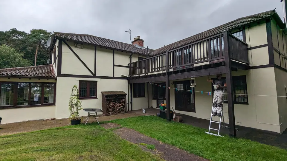 Tudor-style house: black timbers, cream render and balcony