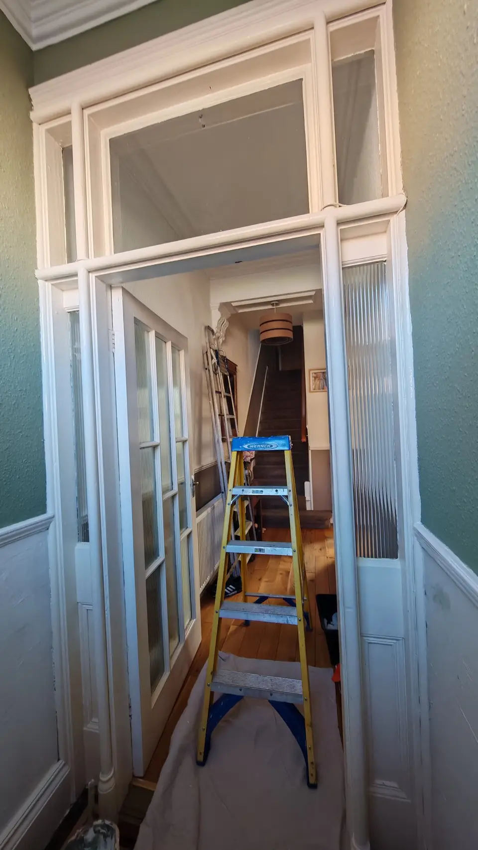 Vestibule screen in white gloss, door open to the hallway beyond