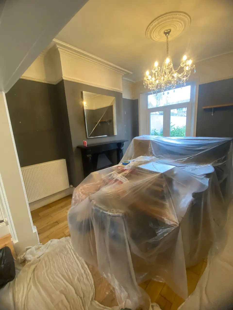 Before: dull grey dining room, furniture wrapped in polythene and dust sheets
